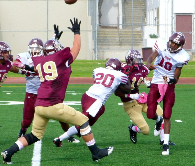 Kearny junior quarterback Stephen Pulley fires a pass over outstretched Point Loma junior defensive end Jake Wambaugh