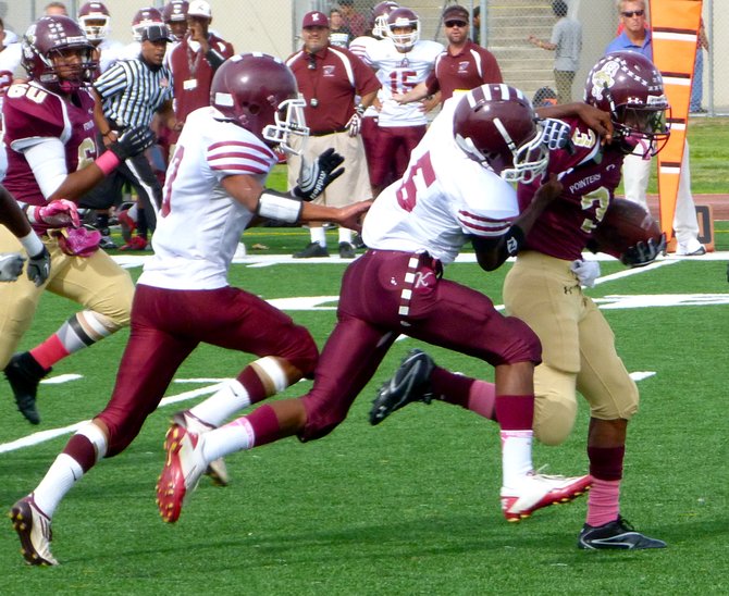 Point Loma junior running back D.J. Lacy races past a pair of Kearny defenders