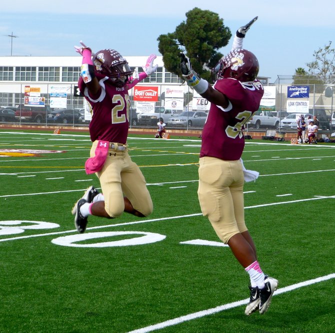 Point Loma senior running backs Sydney Rush (left) and Jamal Agnew meet in midair for a touchdown celebration