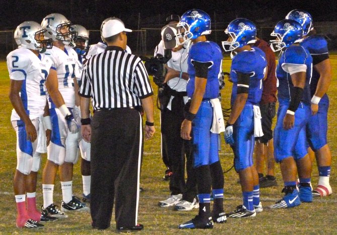 Eastlake and Chula Vista team captains meet at midfield for the coin toss
