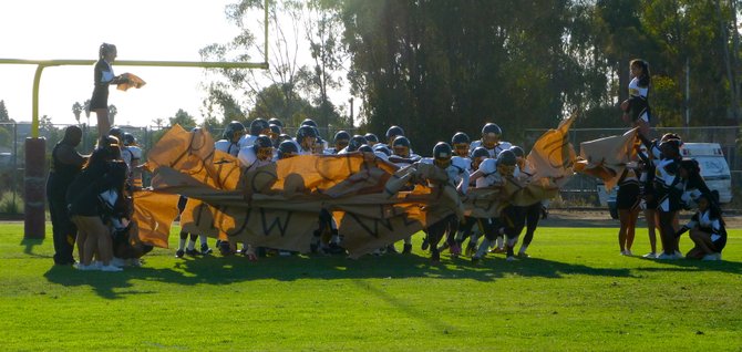 Mission Bay players burst through the banner after halftime