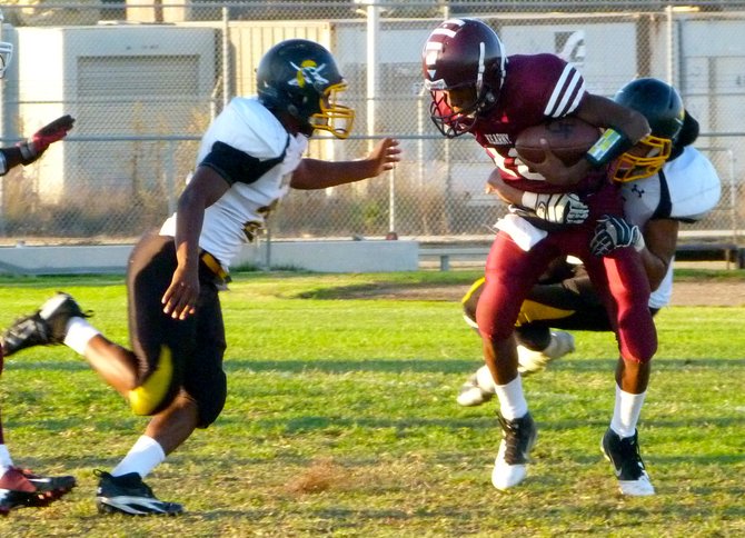 Kearny senior quarterback Stephen Pulley wrapped up by Mission Bay senior linebacker Jo Jo Griffin with a Buccaneers defender closing in