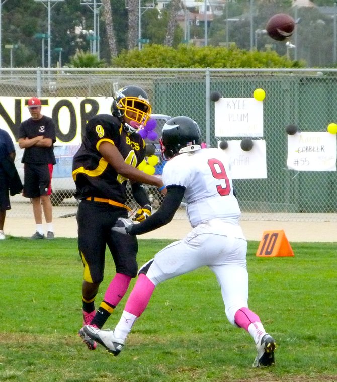 Mission Bay sophomore quarterback Devon Johnson fires a pass with La Jolla senior defensive back David McColl applying pressure