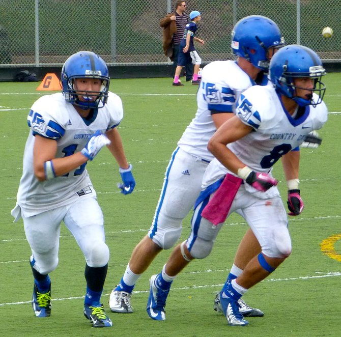 A trio of La Jolla Country Day receivers take off from the line of scrimmage in different directions