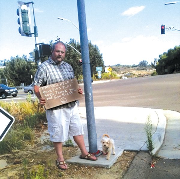Shawn M. (with his dog Boo) solicits money to replace his car’s tires.