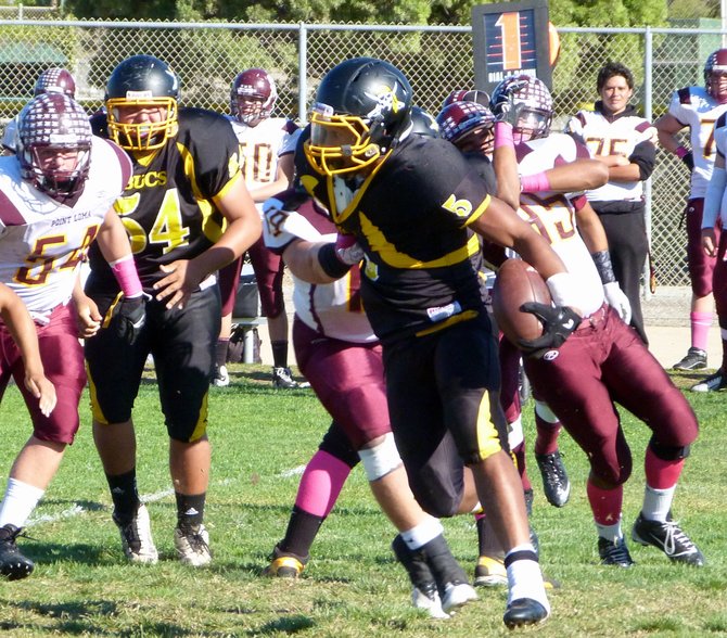 Mission Bay junior running back James Phillips fights for yards with a Point Loma defender latched on