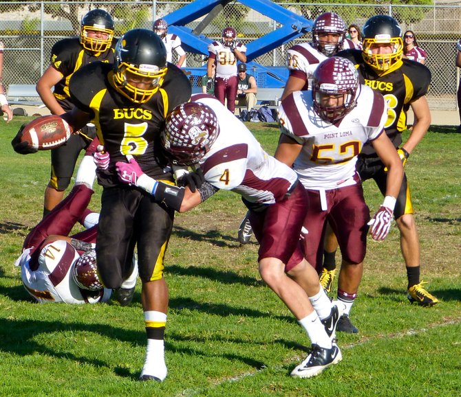 Mission Bay junior running back James Phillips wrapped up by Point Loma junior defensive back Armando Smith