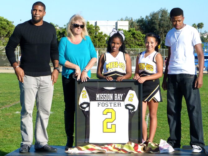 Houston Texans running back Arian Foster stands atop the podium alongside mentor Kathy Agosto, Mission Bay cheerleaders and Buccaneers current No. 2 Rodney Dantzler
