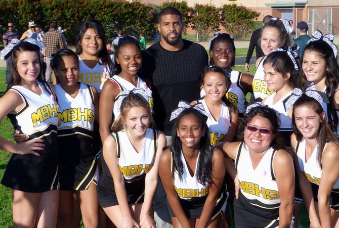 Houston Texans running back Arian Foster stops for a picture with a group of Mission Bay cheerleaders