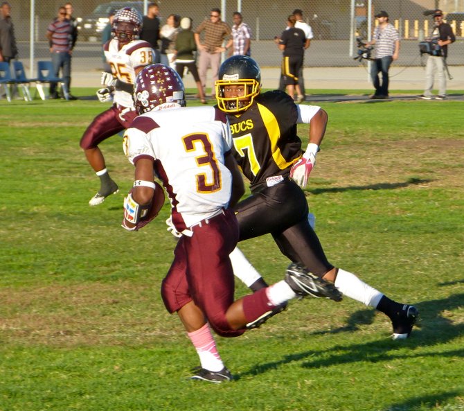 Mission Bay safety Max Pierre keeps his eyes on Point Loma junior running back D.J. Lacy as Lacy carries the ball outside