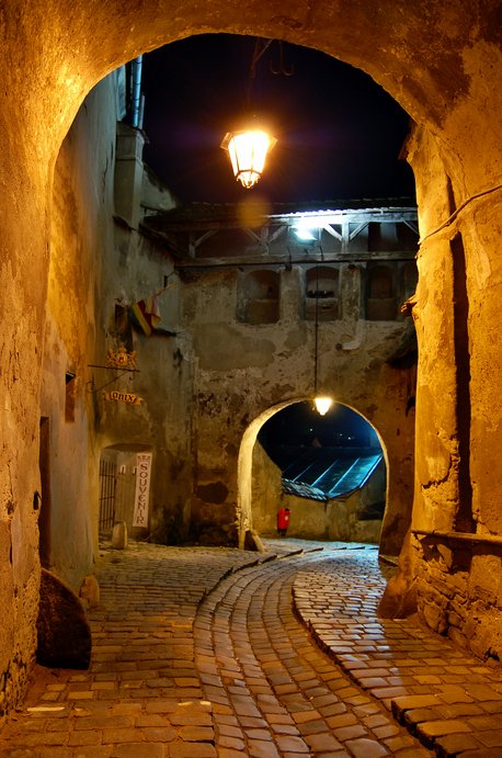 A winding cobblestone pathway underneath Sighişoara's 13th-century Clock Tower.