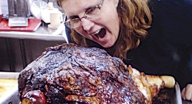 A woman after Bedford’s heart: Sandy, owner of the Cheese Shop, pretends to tuck into a 60-pound 
“steamship round”of beef.
