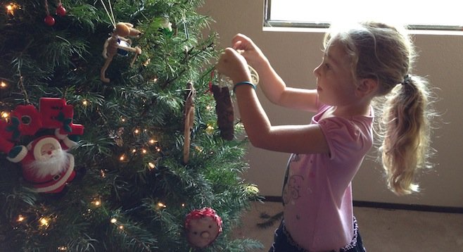 Olivia carefully arranges an ornament
