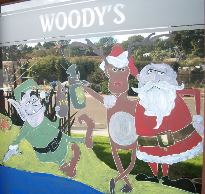 At Woody’s Solana Beach, Santa appears drunk. Employee Jessica Shrader painted two window scenes on the Coast Hwy. bar and restaurant.