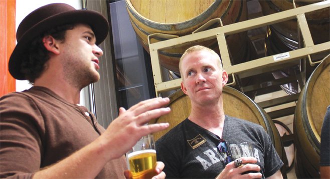 Societe Brewing Company's Doug Constantiner shows a customer around the company's newly installed barrel house.
