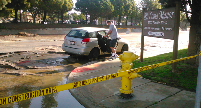 A Point Loma resident assesses damage to his car on Nimitz Boulevard