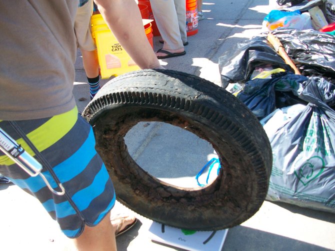 Weighing a rusty tire found at a Surfrider beach clean-along Tourmaline in PB.