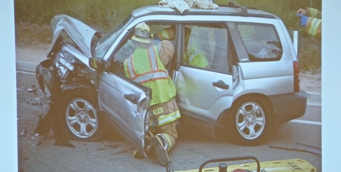 Evidence photo of emergency responders extricating a survivor from the smashed Subaru.  