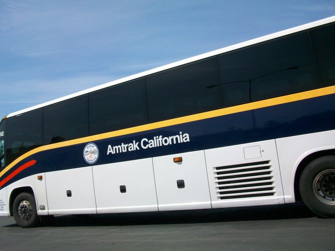 Amtrak bus parked in Clairemont near train tracks.
