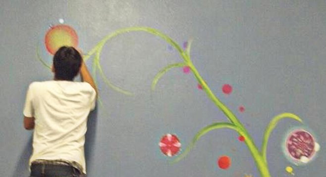 Escondido Arts Partnership artists paint a mural of the mandala tree at the Winter Shelter.