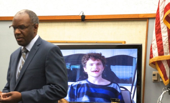 Defense attorney Michael Washington next to a photo of autistic man, Jamey.  Photo Weatherston.