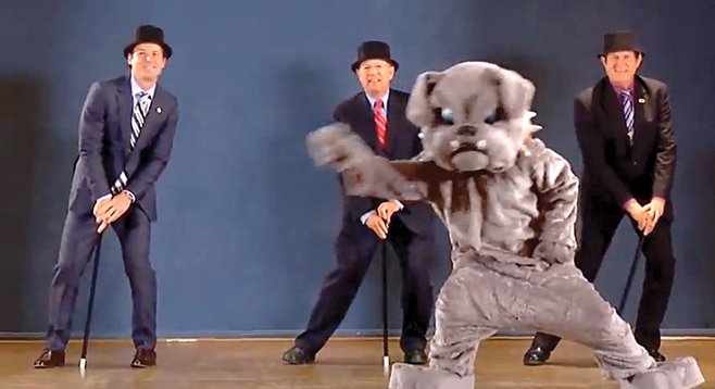 Missed his calling?  City attorney Jan Goldsmith (left) dances behind someone in a dog suit.