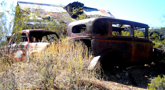 Rusted-out shells of old cars in Vulture City. 