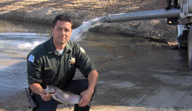 A ranger displays a trout while the lake is restocked (from lakejennings.org)