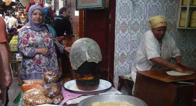 Vendors making pastilla in Fes's bustling medina. 