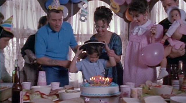 Leo blows out the birthday candles while DeNiro looks on.