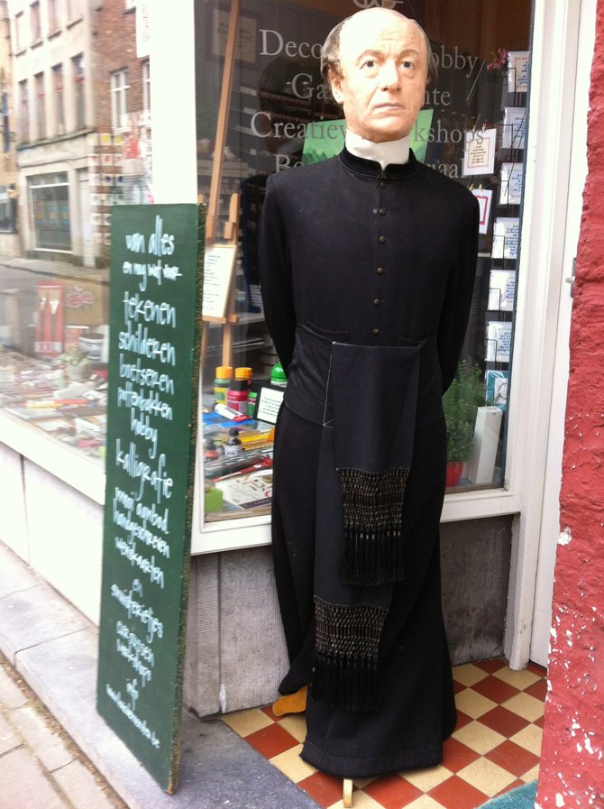A stern wax-figure priest greets decadence-seeking shoppers. 