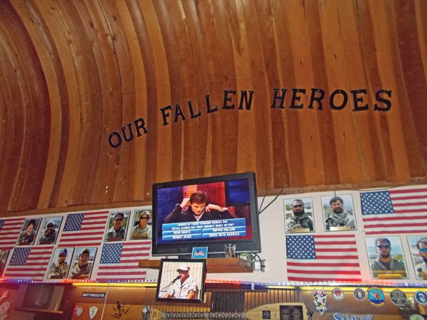 A photo of Chris Kyle, who was killed in February by a troubled ex-Marine, hangs in McP’s shrine to fallen heroes.