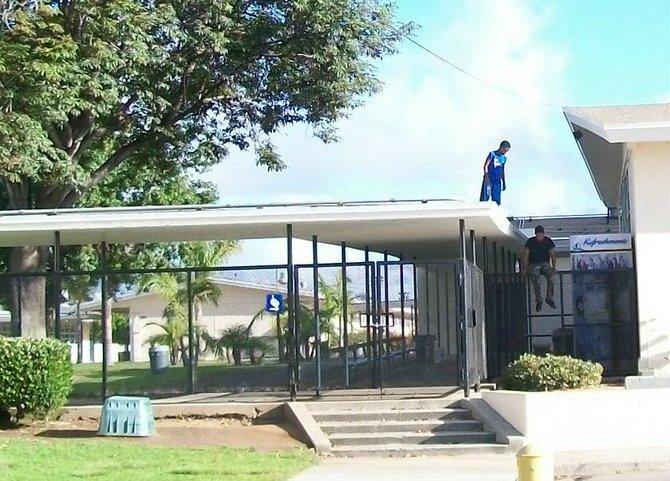 Two boys were seated on the Mar Vista Middle School roof drinking bottled water. 
