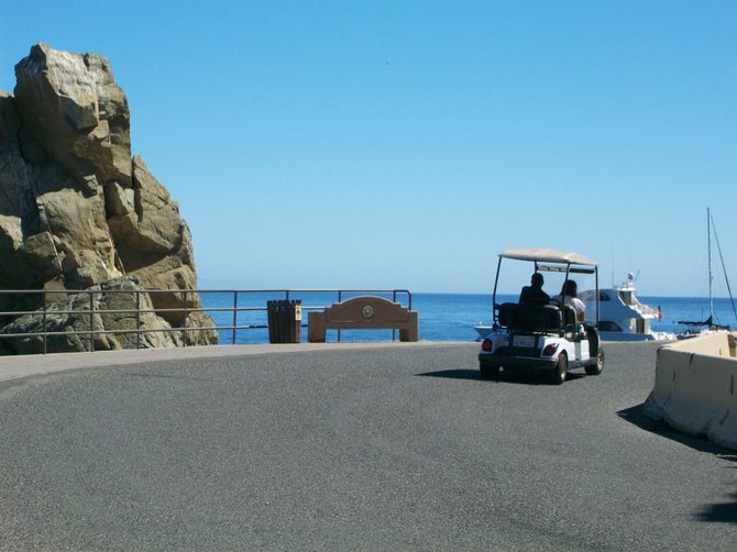 Golf carts drive along Pebbly Beach Road on Catalina Island.