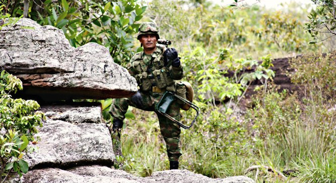 A sniper keeps watch for FARC guerrillas near Caño Cristales.