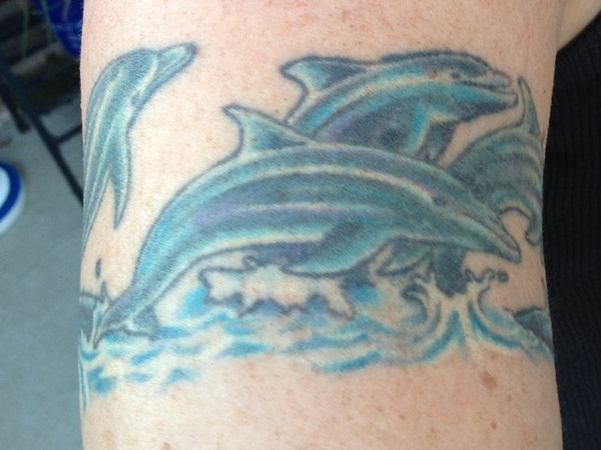 I got this arm band 10 yrs ago as a gift to myself for having a baby at 40. I've always loved dolphins and have felt a connection with then. I actually found a shirt at sea world that had the look I wanted. I found this outstanding artist Doug Bowen who at the time was working in Temecula (he is now at Front line tattoos in Vista) he drew it up for me and put his "swing" to it.  I love it! I still get comments on it all the time. I live in Vista I've been here almost 30 years. When I can afford it I'd love to go see Doug again -I do have several from him-wouldn't go to anyone else!! Haven't seen him in 10 yrs but I can only imagine you get even better with time. 