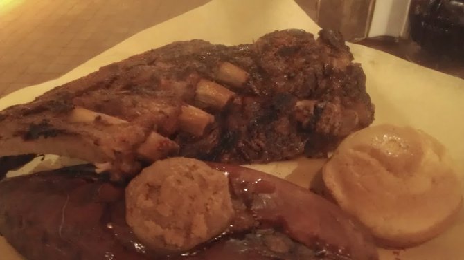 Vaguely discernible pork and beef ribs in poor lighting.