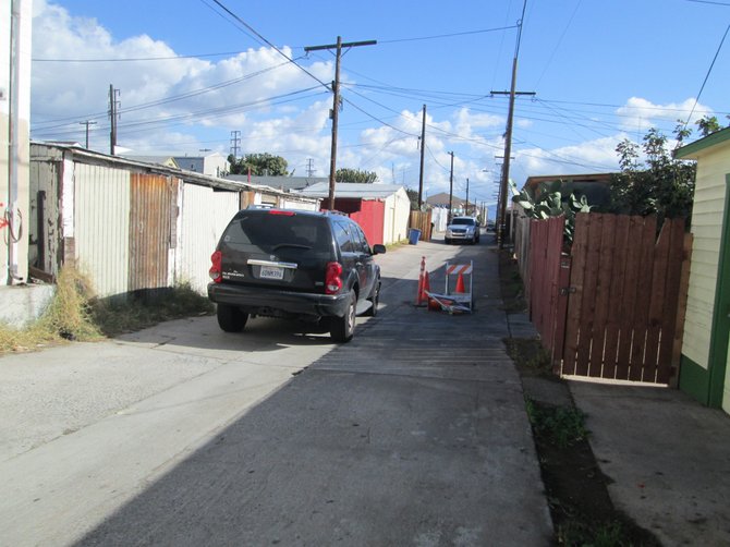 Alley behind the house where the raid was taking place.  Unmarked vehicles blocking alley from both ends.  The open wooden gate is the house where the raid took place.