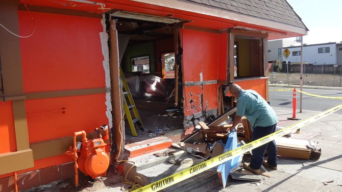 A worker cleans up debris after a car crashed into Colima's Mexican Food on the NE corner of University Avenue and Louisiana Street in North Park. It reportedly happened about 2 a.m. on December 6. There was major damage to one wall, and the eatery was closed when I went by today around noon.
