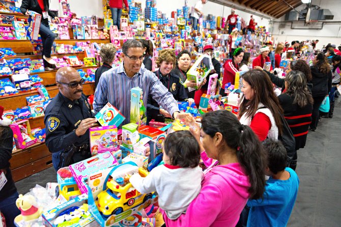 Miles McPherson, Rock Church senior pastor, and Shelley Zimmerman, the Assistant Police Chief for San Diego, hand out toys in the toy room at Toys for Joy. (The Studios of Joseph Guidi Photo/ Joseph Guidi)