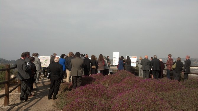 A crowd gathers overlooking San Dieguto Lagoon for a presentation on planned projects below