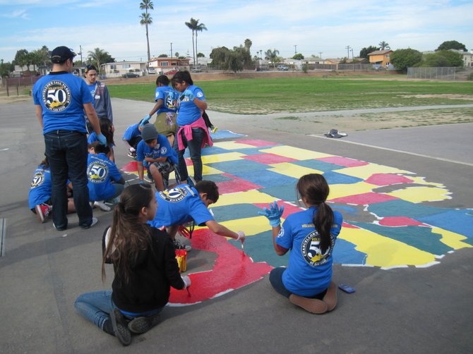 On Sunday, January 19th, Chancellor Pradeep Khosla of the University of California, San Diego (UCSD) visited Bayside Elementary School to support the Martin Luther King, Jr. National Day of Service event with UCSD students, staff and alumni volunteering with Bayside students and staff. Pictured are volunteers painting a map of the United States on the Bayside playground. 