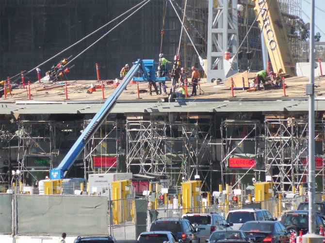 Construction crew assembles light towers with tension struts to support columns