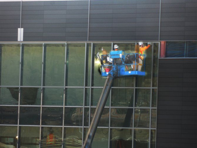 Men on a crane installing windows