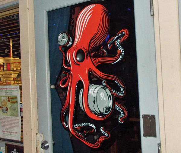 On the wall, a giant red octopus has wrapped his tentacles around a beer barrel. The company logo.