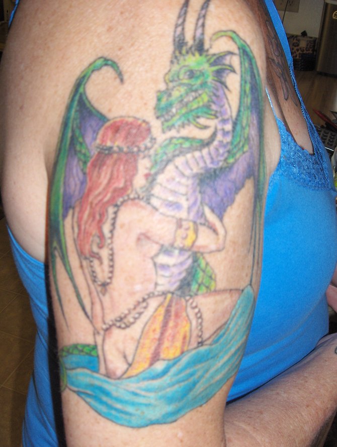 In 2005, I had this tattoo done by Heather Sinn at Avalon in P.B. It was done just weeks before starting chemotherapy. It symbolizes embracing your demons, facing your fear, "taming the dragon". It gave me strength then, and still does. 
Denise 52 Lakeside Retired