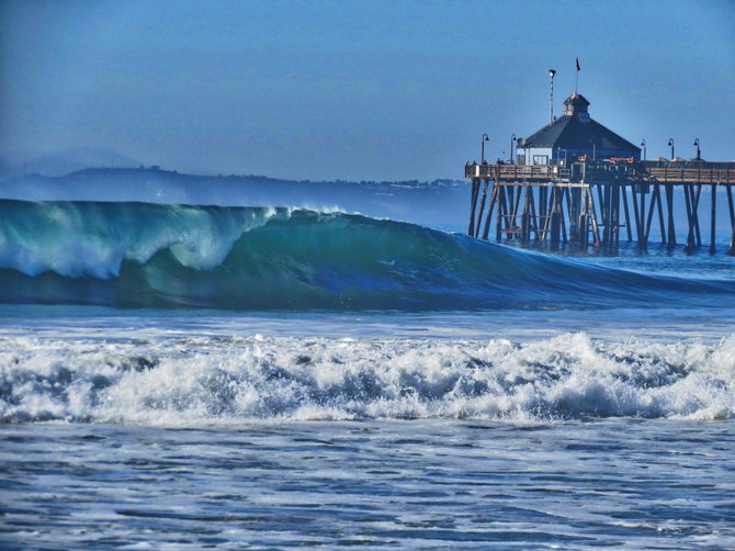Large wave breaking next to Imperial Beach pier.