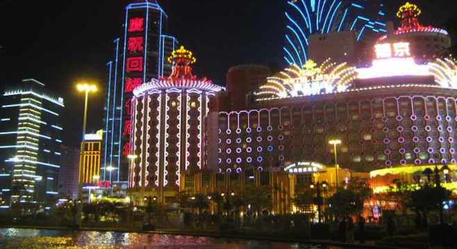 The bright lights of Macau's casino district at night. 
