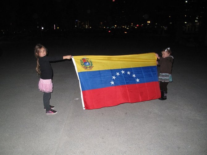 Girls supporting Venezuela holding their flag.