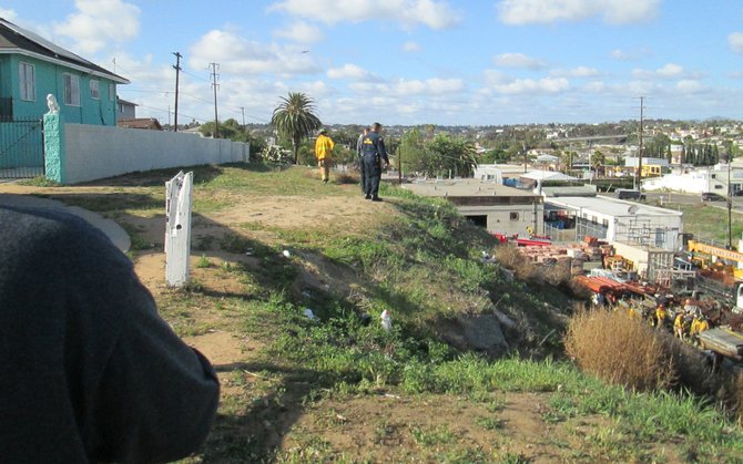 Photo taken from Newton Avenue clifftop, looking down on the site.  Fire personnel working around the location of the fire.